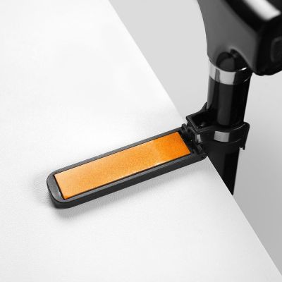 Gehstockhalter mit orangem Reflektor und schwarzer Klemmhalterung am Tischrand