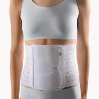 Thorax-Abdominal-Stütze in Weiss mit breiten Pelotten und Gurten, am Bauch getragen